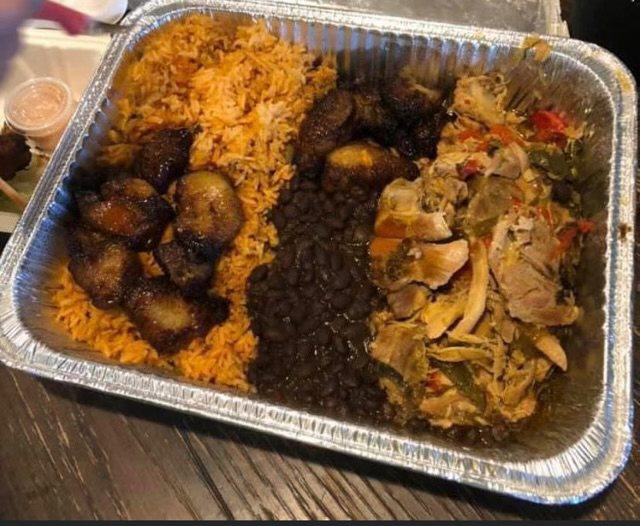 Full catering tray with yellow rice, beans, maduros and stewed chicken