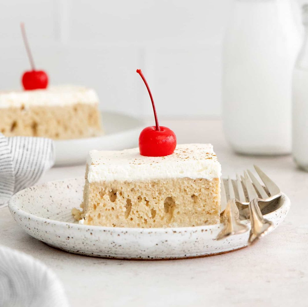 Creamy tres leches cake topped with a cherry